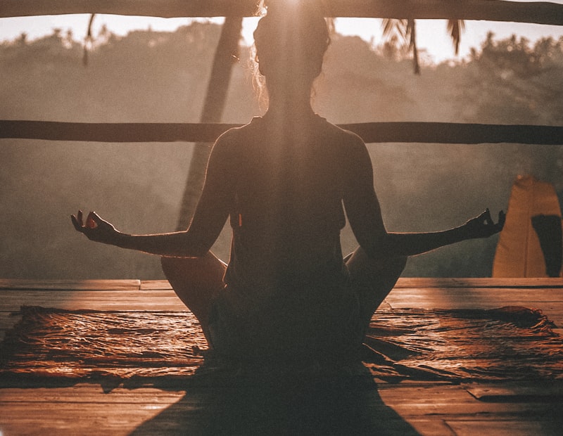 Woman practicing yoga at sunrise